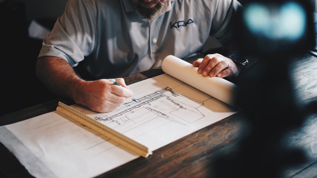Engineer marking up a construction blueprint at a desk