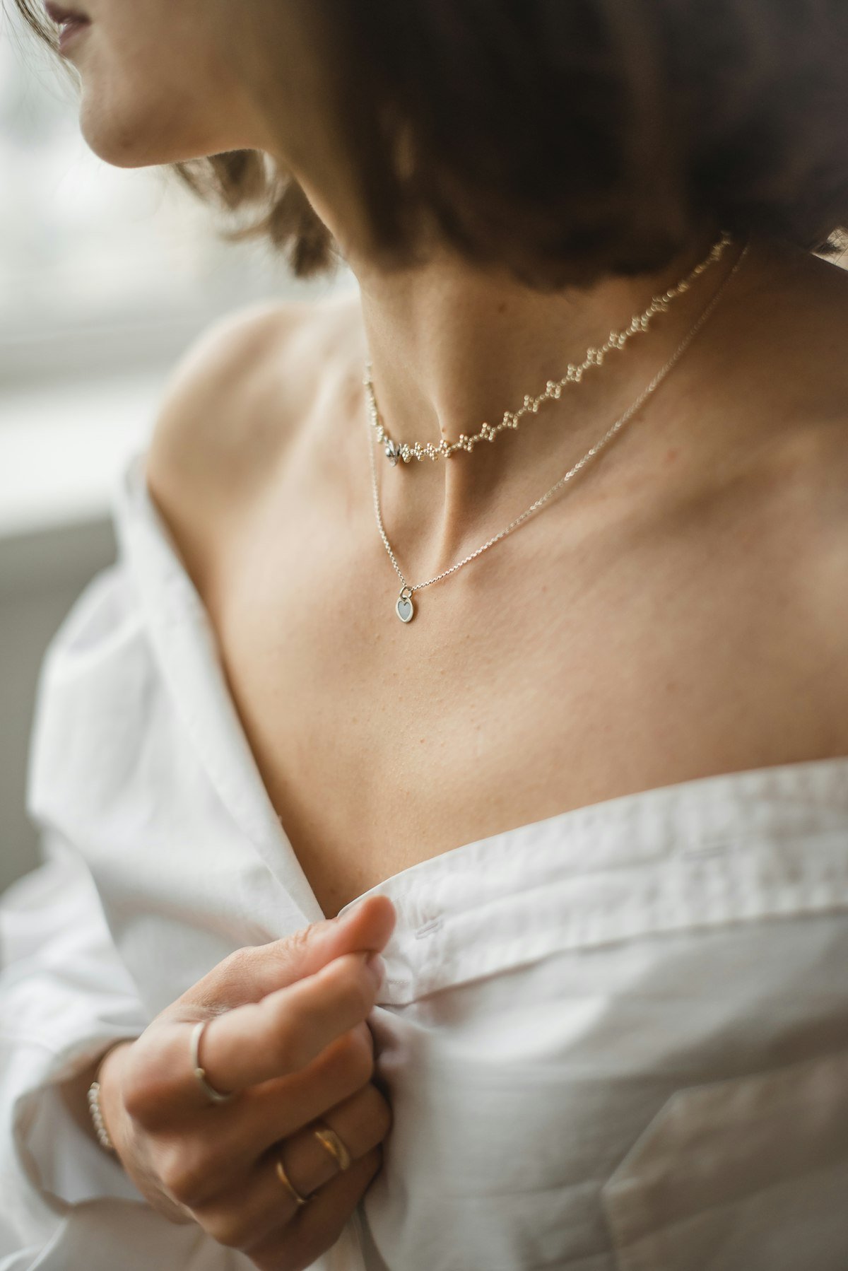 Model wearing delicate necklaces and rings in a jewelry lookbook