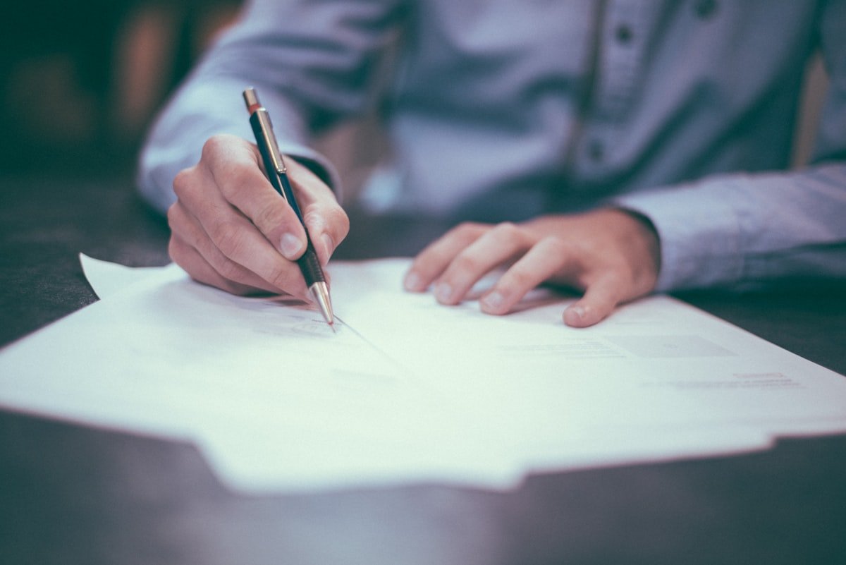 Client signing a legal document at an attorney consultation