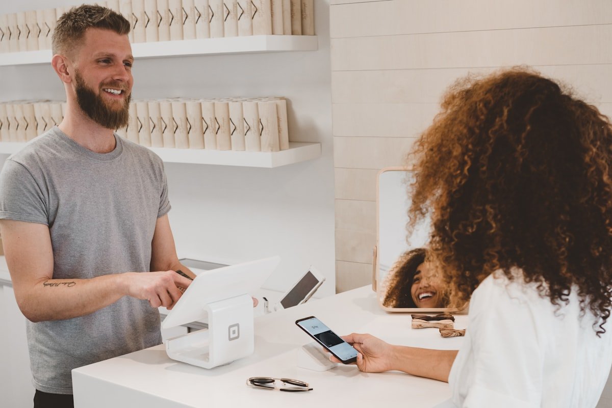 Small business owner serving a customer at a retail checkout